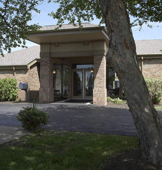 A building entrance with a tree in the foreground.