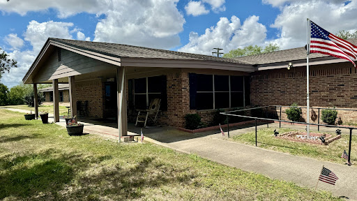 A charming residential home with a well-maintained lawn and clear blue skies.