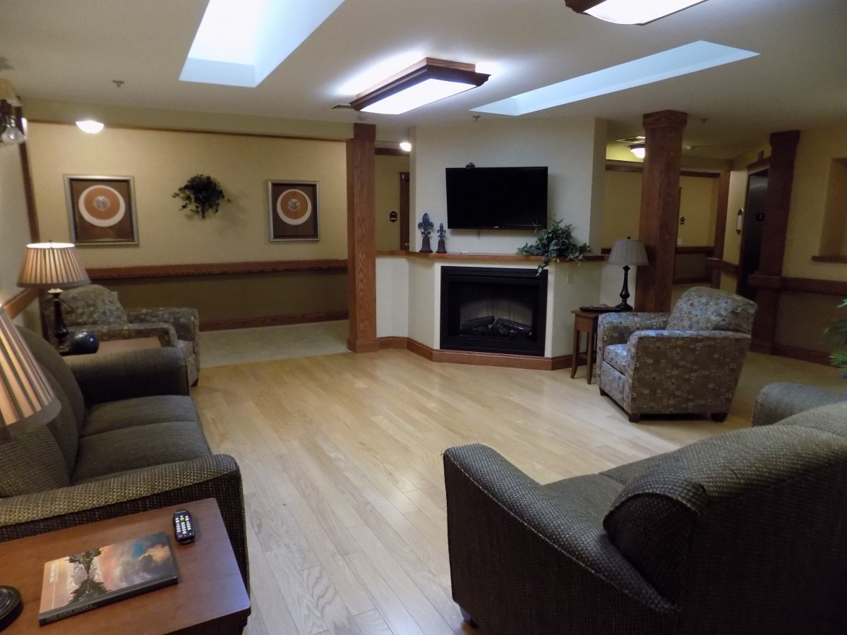 A cozy living room featuring comfortable sofas, a fireplace, and a television.