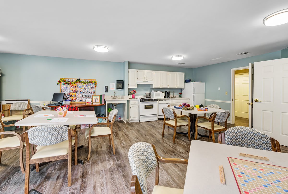 A community kitchen and dining area with tables, chairs, and cooking appliances.