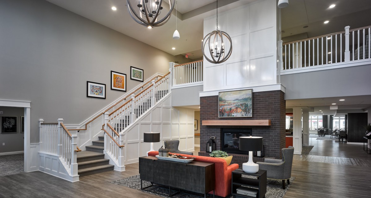 A modern living room with a stylish staircase, elegant chandeliers, and contemporary artwork.