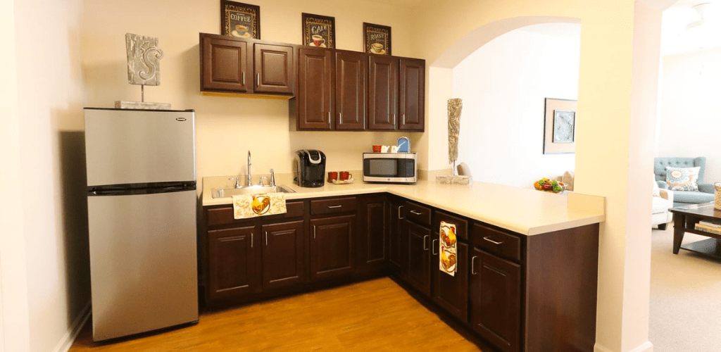 A modern kitchen with dark wooden cabinets and stainless steel appliances.