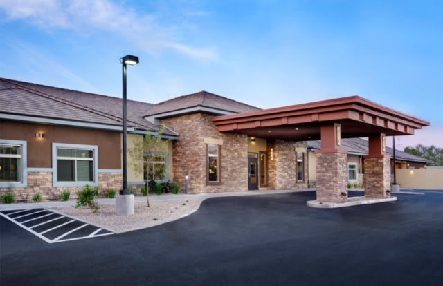 The entrance of a modern healthcare facility with stone accents and a covered driveway.