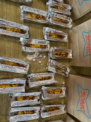 A collection of individually wrapped snacks displayed in silver foil on a table.