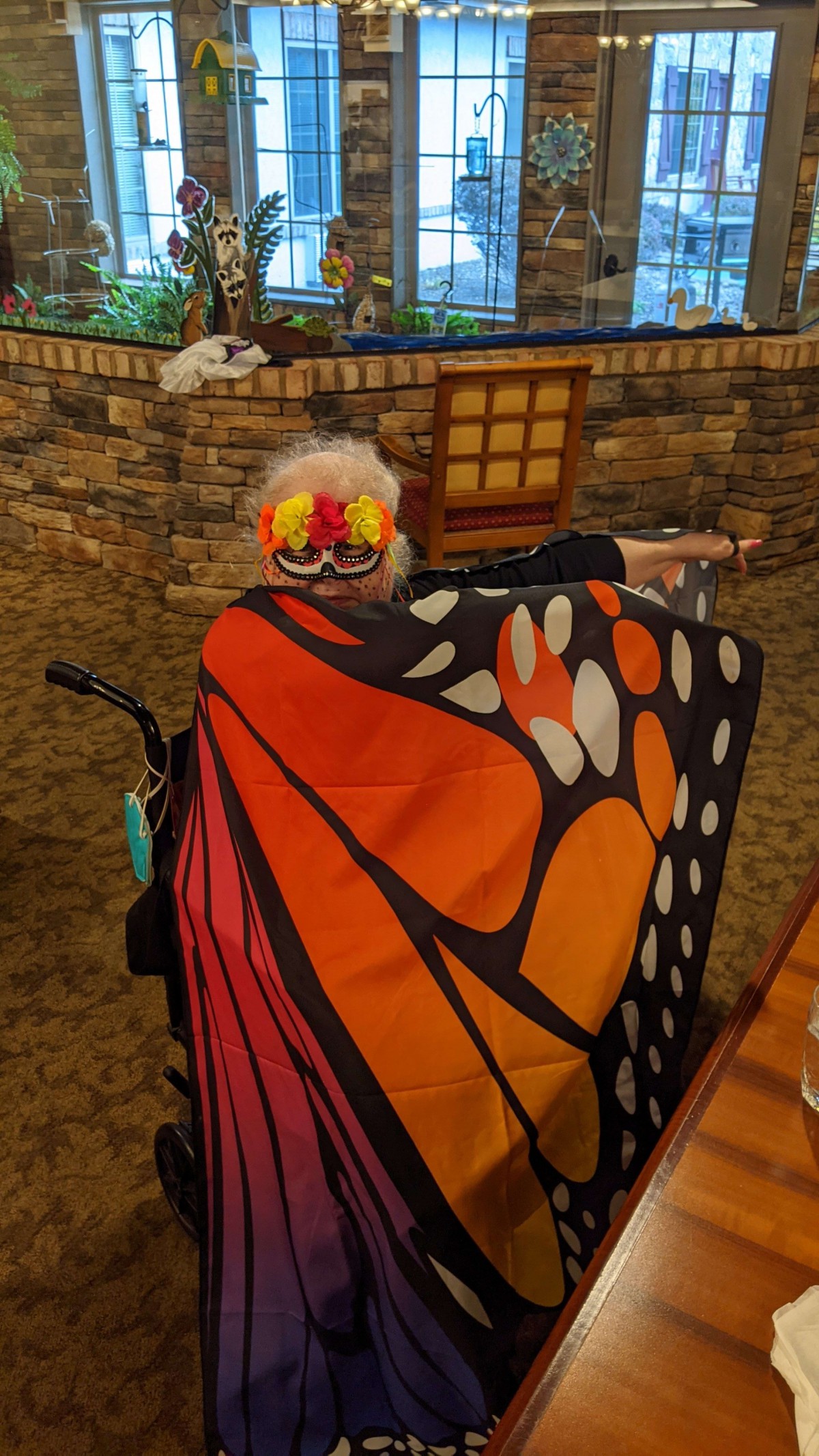 Person wearing a butterfly costume and mask indoors.