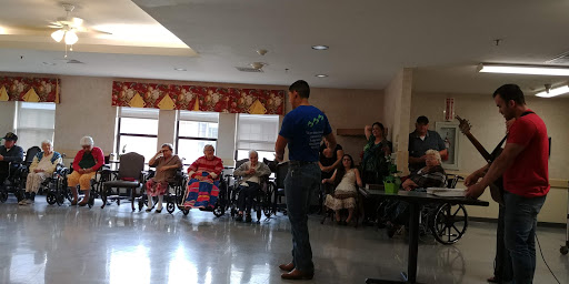 A speaker engaging an audience of elderly individuals in a community setting.
