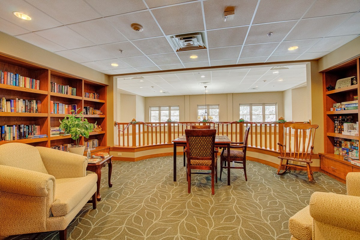 A cozy library space with bookshelves, a table, and chairs.