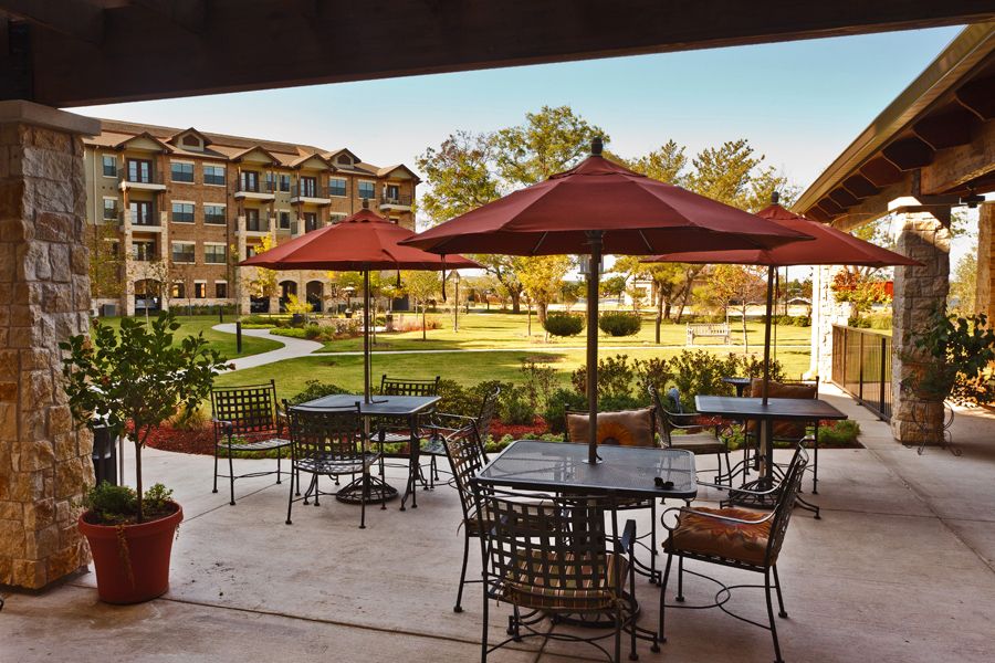 A serene patio with tables and umbrellas overlooking a garden area.