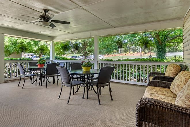 A cozy patio with outdoor seating and greenery.
