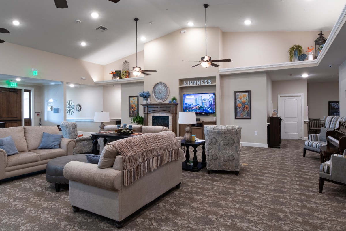 A spacious and elegantly designed living room featuring comfortable sofas, a fireplace, and a large television.