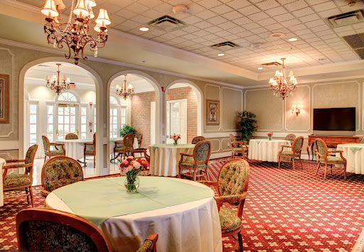 An elegant dining room featuring beautifully set tables under ornate chandeliers.