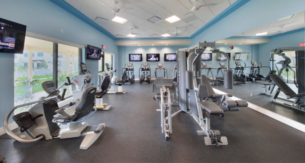 A modern gym with various fitness equipment including treadmills and weight machines.