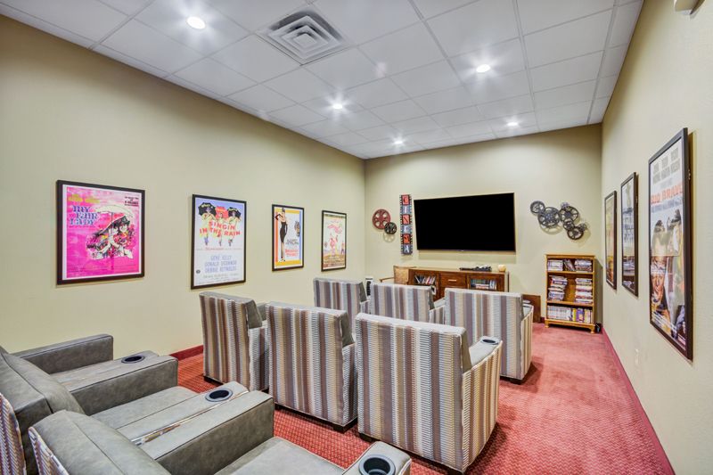 A cozy home theater setup with striped seating and classic movie posters on the walls.