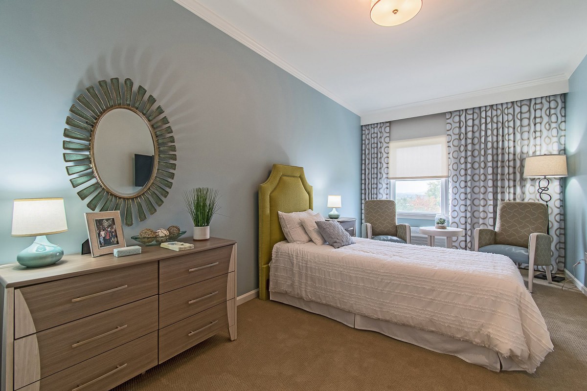 A cozy bedroom featuring a single bed, modern furnishings, and soft neutral tones.