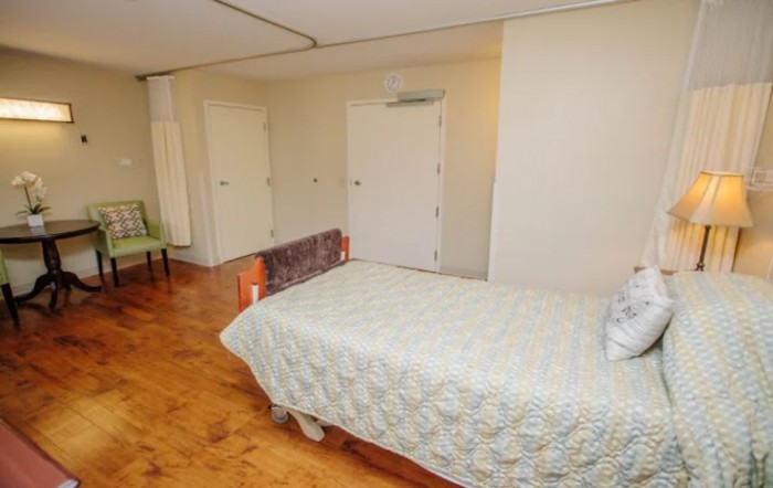 A minimalist bedroom with a single bed and wooden flooring.