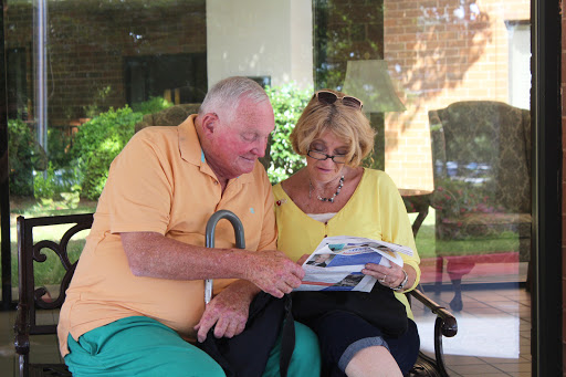 A senior couple enjoying a moment together while reading outdoors.