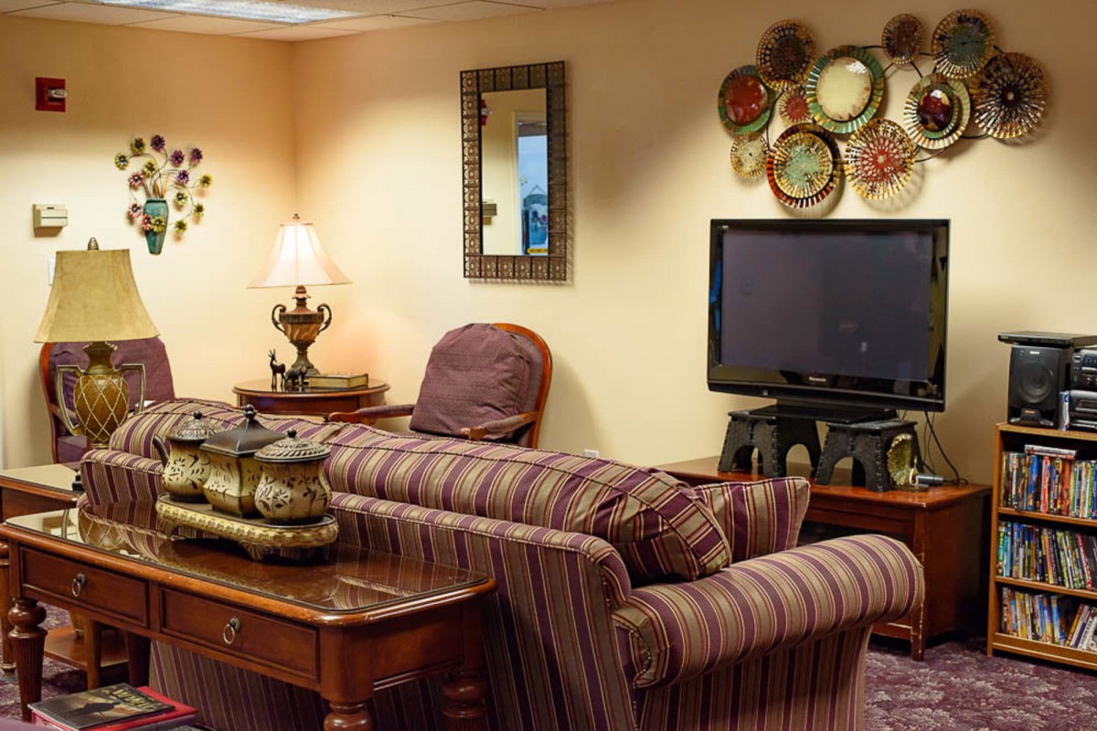 A cozy living room with a striped sofa, television, and decorative elements.