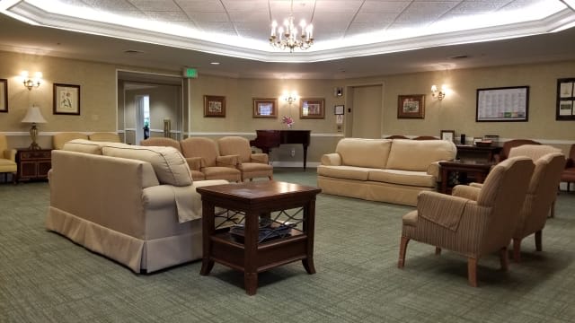 A cozy living room with comfortable sofas, a central coffee table, and a chandelier providing overhead lighting.