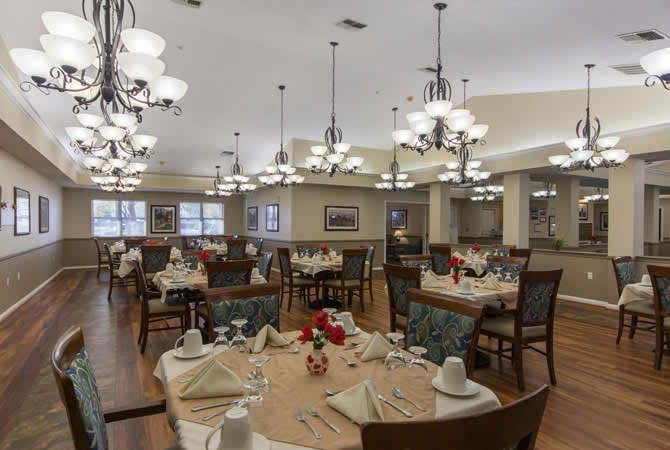 An elegant dining room with neatly arranged tables and chandeliers.