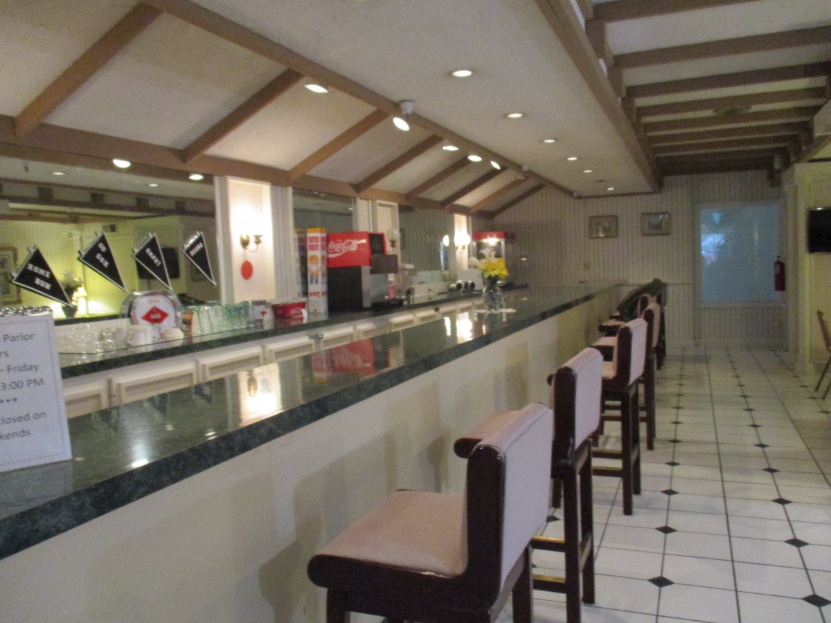 An empty bar with high chairs and a modern interior design.