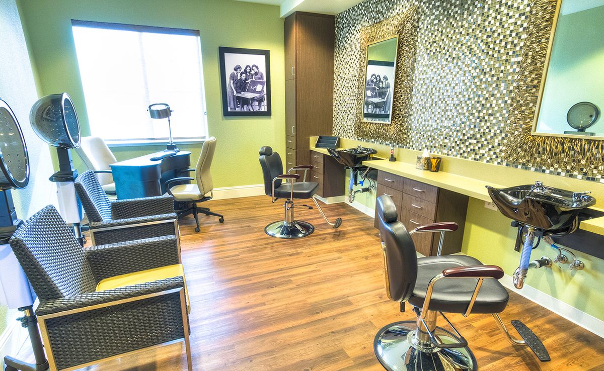A modern hair salon interior with stylish chairs and mirrors.