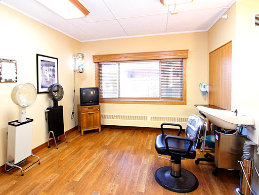 A well-lit dental clinic room featuring a patient chair, waiting area, and window for natural light.