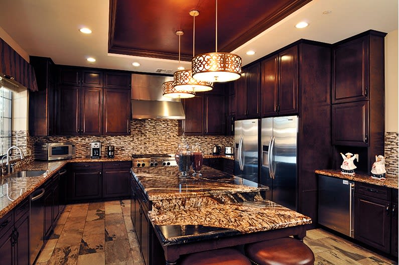 A luxurious modern kitchen with dark wood cabinets and granite countertops.