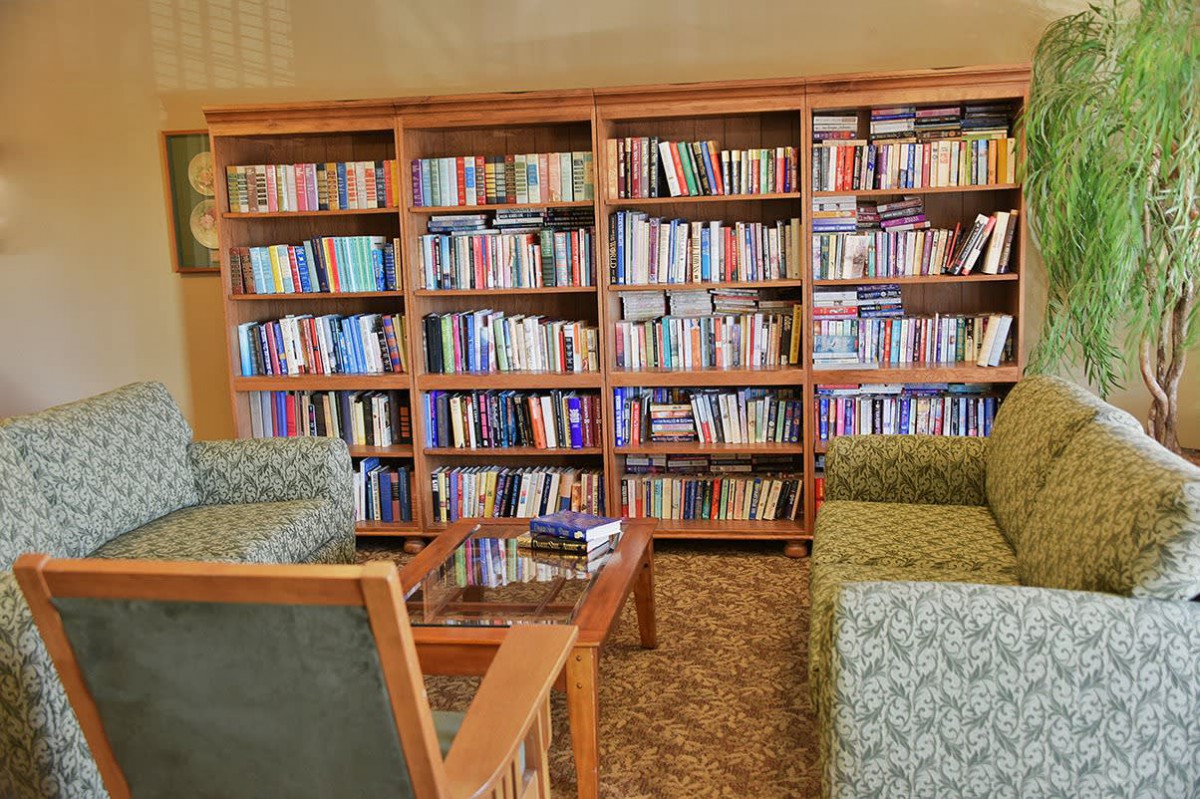 A cozy reading area with bookshelves filled with books and comfortable seating.