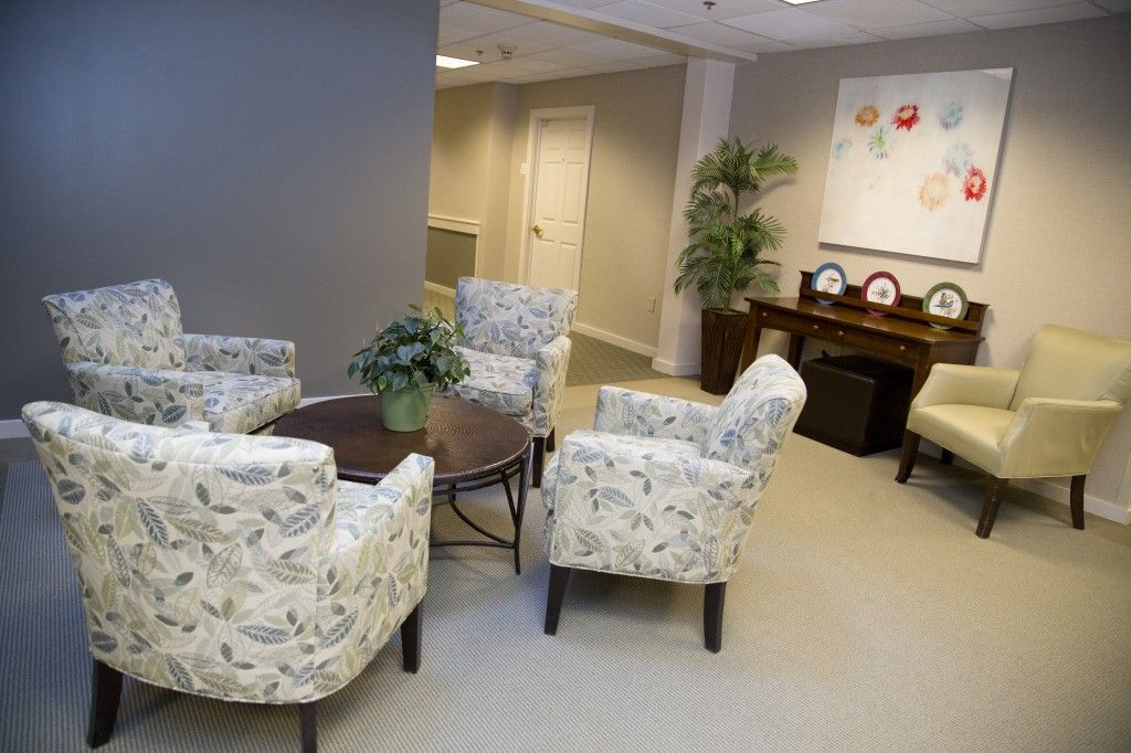 A cozy waiting room with patterned chairs and a round table.