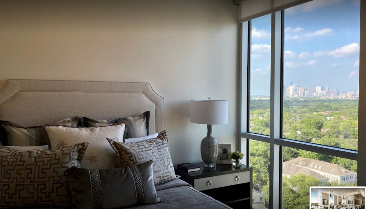A modern bedroom with a large window showcasing a scenic view.