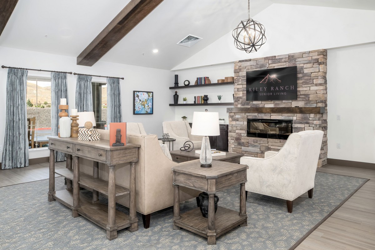A modern living room with a cozy ambiance featuring a stone fireplace, comfortable seating, and stylish decor.