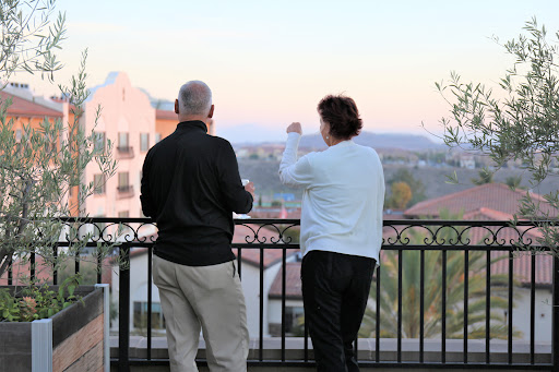 A couple enjoys a scenic view from a balcony during sunset.