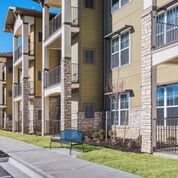 Modern apartment complex with balconies and landscaped surroundings.