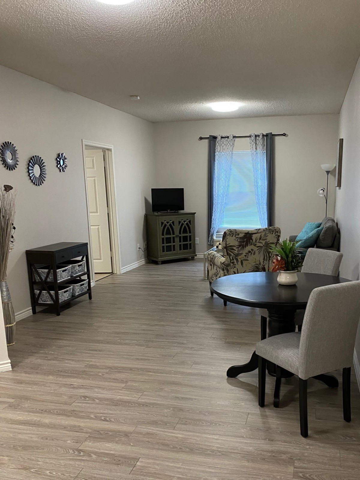 A cozy living room with a table, chairs, and a television.