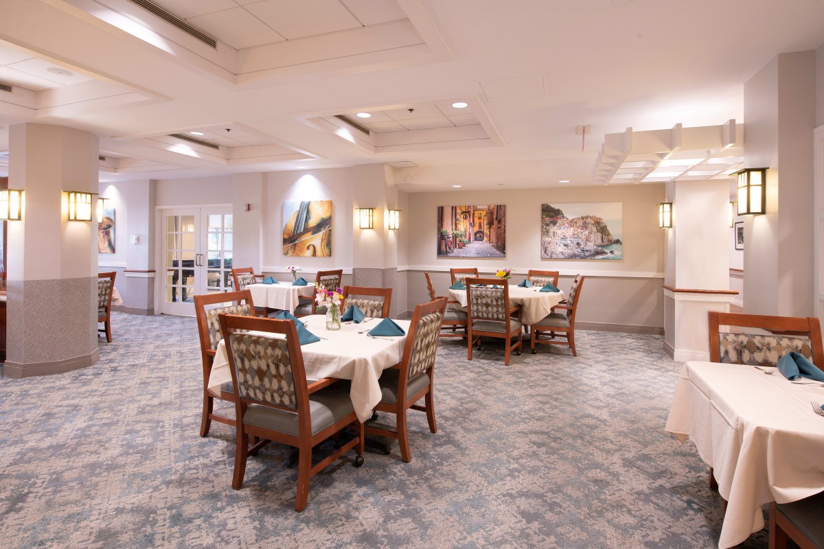 A well-lit dining area with neatly arranged tables and chairs.