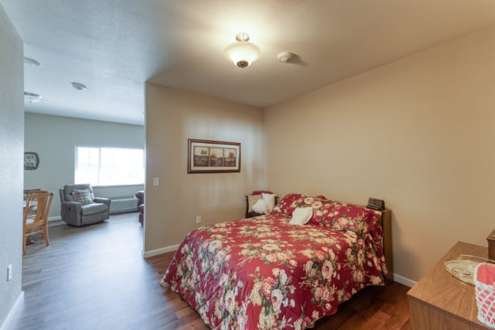 A cozy bedroom with a floral bedspread and warm lighting.