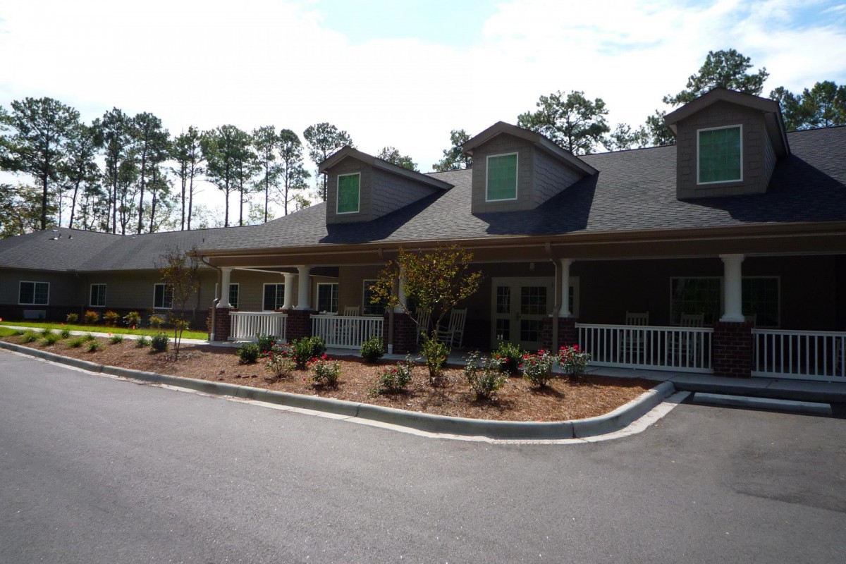 A residential building with a landscaped front yard and driveway.