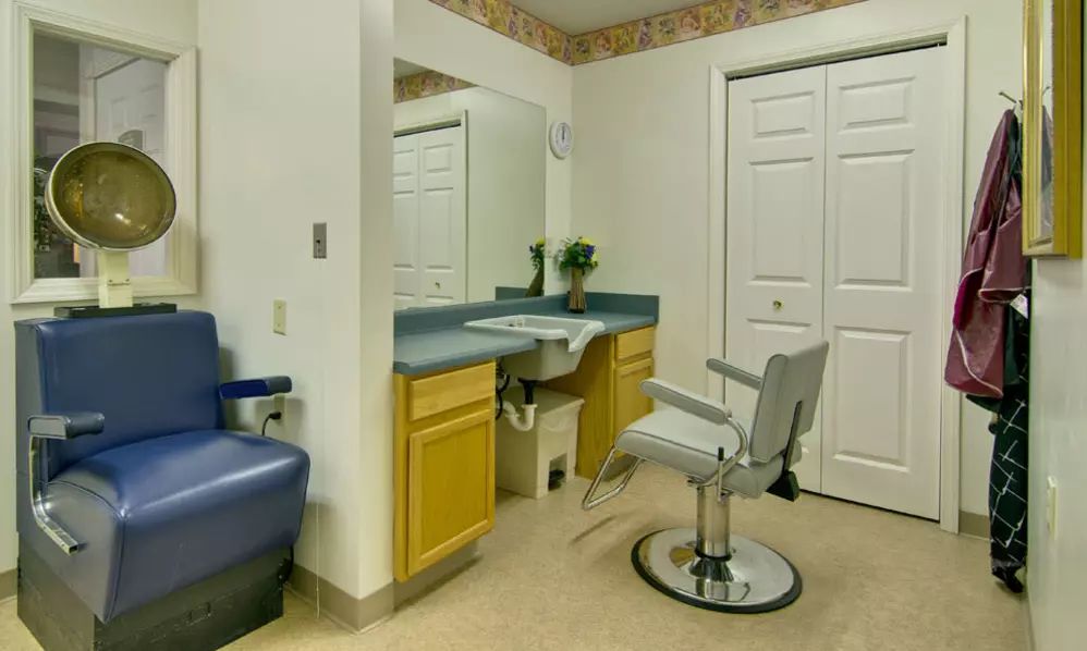 A hair salon interior with a styling chair and mirror.
