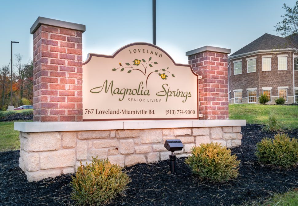 Entrance sign for Magnolia Springs community with a brick and stone structure.
