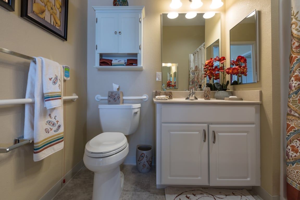 A well-organized bathroom with a toilet, sink, and wall-mounted cabinet.