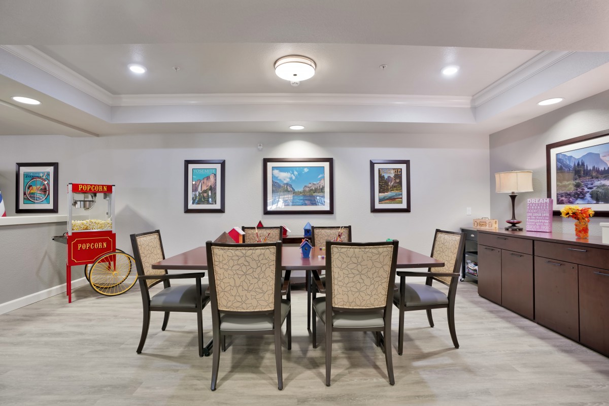 A modern dining room featuring a large table surrounded by chairs and adorned with artwork on the walls.