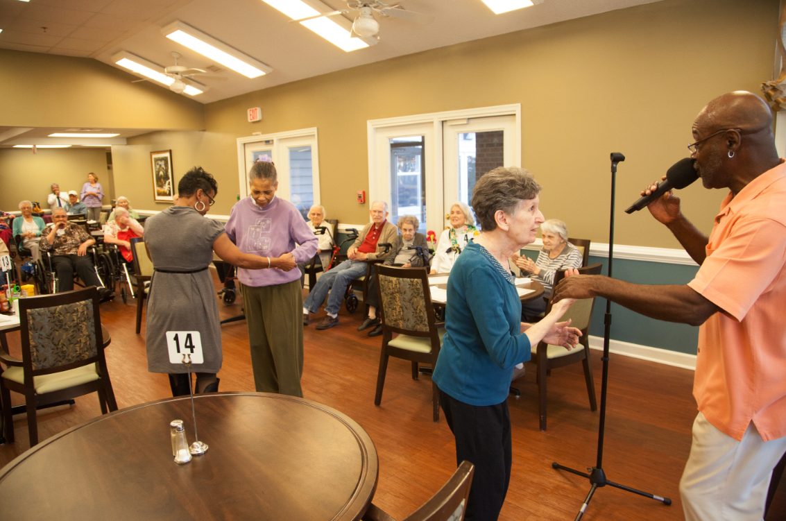 A group of people enjoying a dance event at a community center.