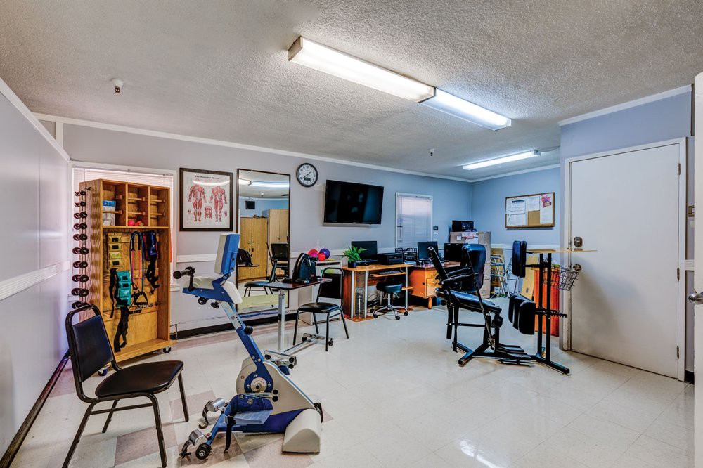 A physical therapy room equipped with various exercise and rehabilitation machines.