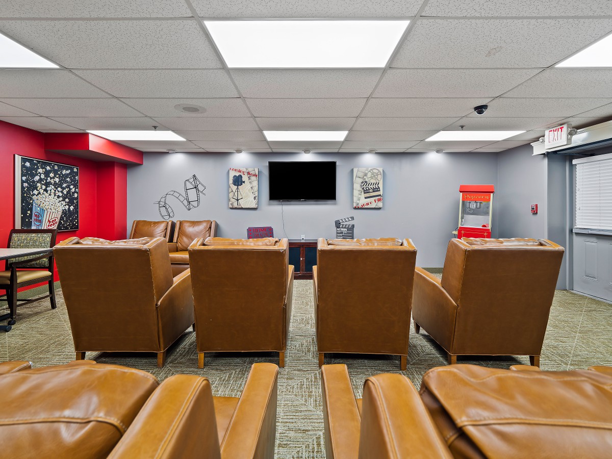 A cozy home theater setup with comfortable seating, a large television screen, and a popcorn machine.