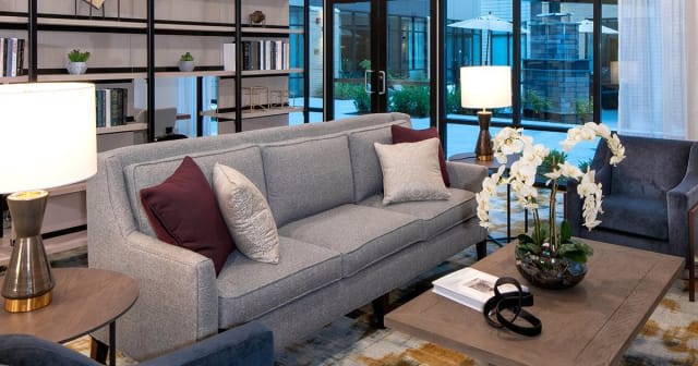 A modern living room featuring a comfortable gray sofa with decorative pillows, a stylish coffee table, and elegant lighting.