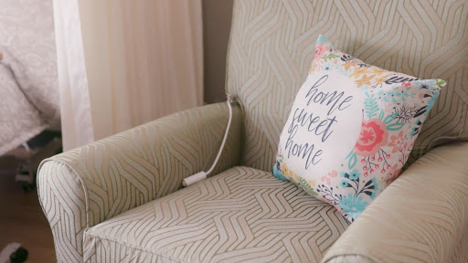 A cozy chair adorned with a decorative pillow that brings warmth to any space.