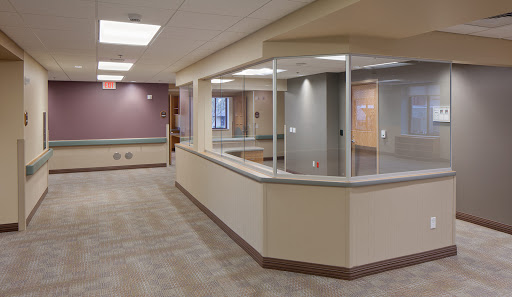 A modern and spacious healthcare reception area featuring glass partitions and soft color tones.