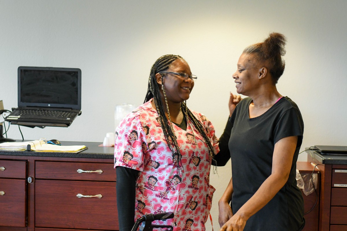 A nurse providing care and support to a patient in a medical office.