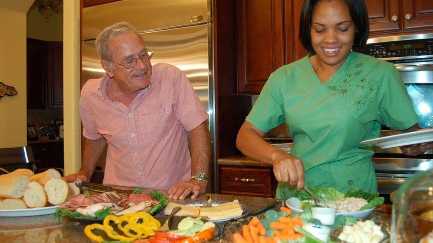Two people preparing a variety of fresh vegetables in the kitchen.