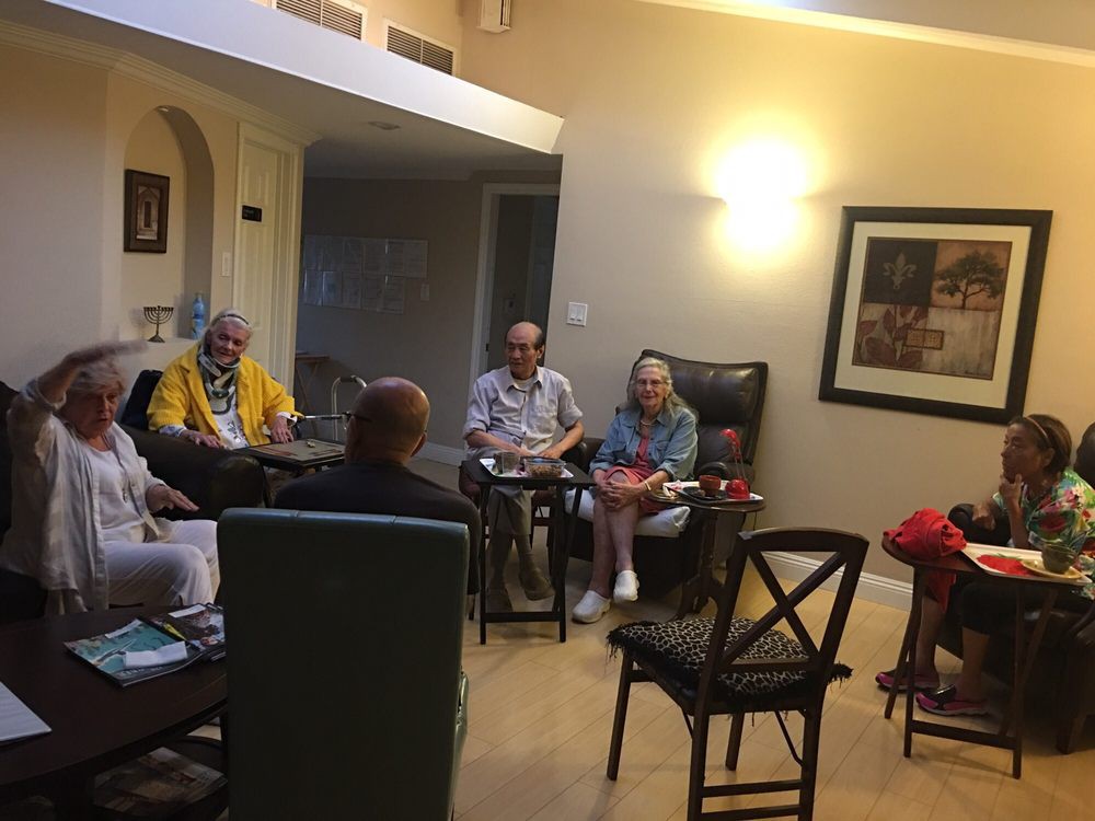 A group of people having a conversation in a cozy living room.